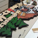 Mit Maske und Farbe bemaltes Holzschild